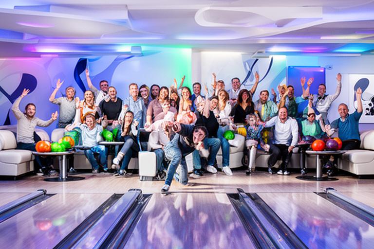 Gruppe beim gemeinsamen Bowlingabend in einem hell beleuchteten Bowlingcenter in Schneeberg